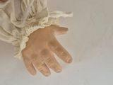 a doll hand that is holding something in it ' s hand