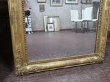 un grand miroir posé par terre devant une chaise