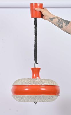 someone is holding a red and white object in their hand
