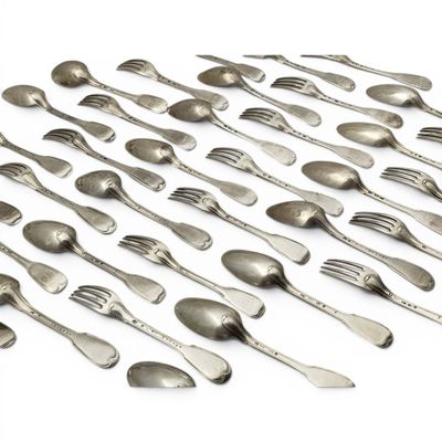 un grand nombre de cuillères et de fourchettes en argent disposées sur une table