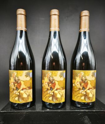trois bouteilles de vin posées sur une table en bois