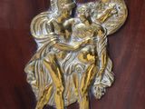 a gold statue of a woman and a child on a wooden door