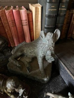 de nombreux livres posés sur la table, sur laquelle se trouvent des statuettes d'animaux