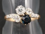 un gros plan d'une bague sertie d'un saphir bleu et de diamants blancs