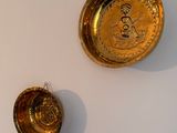 two gold plates on the wall next to each other