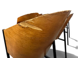 two wooden chairs sitting next to each other on a white surface
