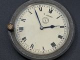 une horloge en argent avec des chiffres romains sur le cadran