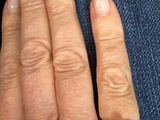 a woman ' s hand with a ring on it