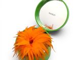a green container with an orange flower inside of it