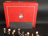 des figurines représentant un groupe de personnes devant une boîte rouge