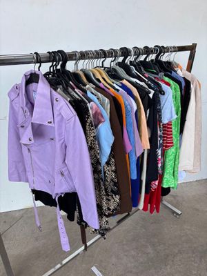 a lot of clothes hanging on a rack in a room