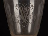 a close up of a wine glass with a monogram on it