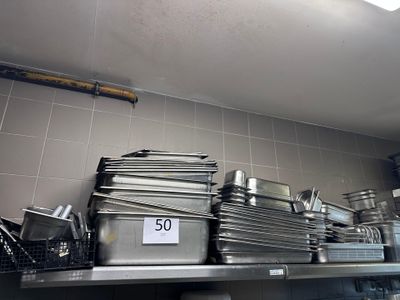 de nombreuses casseroles et poêles sur l'étagère de la cuisine