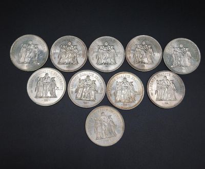 six different types of silver coins on a black surface