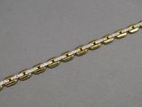 a close up of a gold and diamond bracelet on a gray surface