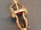 une horloge dorée et rouge accrochée au mur