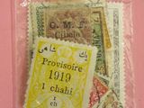 un sachet de timbres-poste posé sur un fond rose