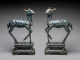 paire de statues en bronze représentant un cerf et une antilope, posées sur des socles