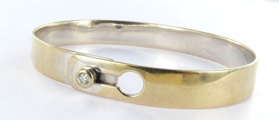 a close up of a ring on a white surface with a diamond