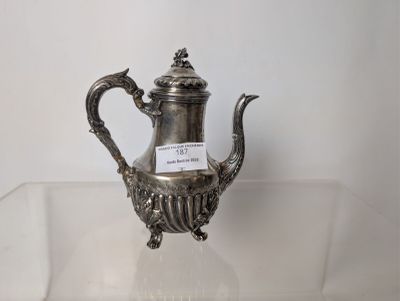 a silver tea pot sitting on a clear glass table