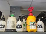 de nombreuses bouteilles de liquide posées sur une étagère dans une pièce