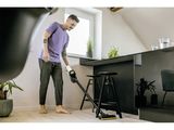 Cet homme passe l'aspirateur sur le sol.