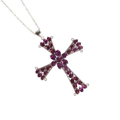 un gros plan d'un collier orné d'une croix sur fond blanc