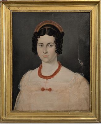 portrait d'une femme en robe rose portant un collier de perles rouges