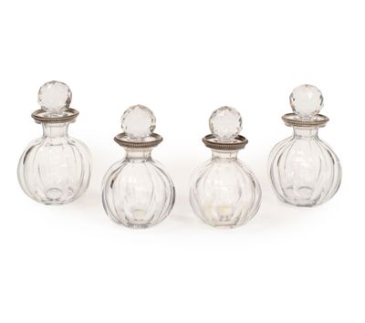 quatre petites bouteilles en verre avec des bouchons en argent et des bouchons en argent
