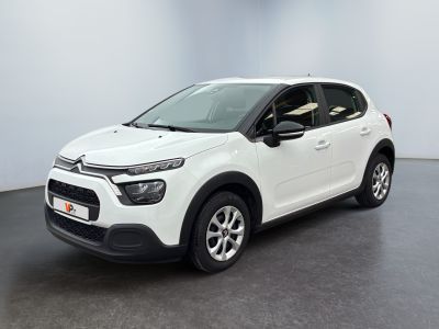 Une Citroën blanche est garée dans une pièce blanche