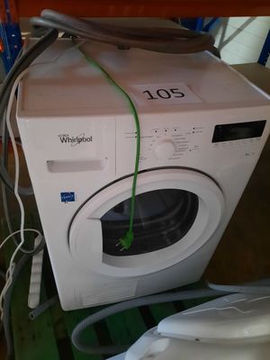 une machine à laver blanche posée sur une table en bois