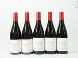 six bouteilles de vin sont alignées sur une surface blanche