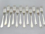 six forks and six spoons are arranged in a row on a table