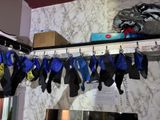 many pairs of wetsuits hanging on a rack