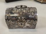 a silver box sitting on a table next to other items