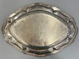 a silver tray on a white table with a silver handle