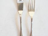 two forks and a knife on a white table