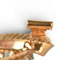 a close up of a gold plated object on a white surface