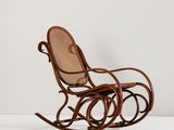 un fauteuil à bascule en bois avec un dossier en rotin et une assise en osier