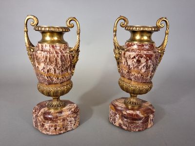 pair of antique vases on marble bases on a gray background