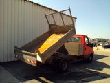 a red truck with a ramp on the back of it