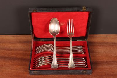 silverware in a red case on a wooden table with a black background