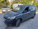 La camionnette est garée sur le parking près des arbres.