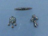 three pieces of jewelry on display on a blue surface