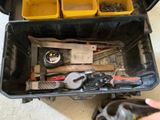 a tool box with tools in it and a person ' s hand holding a tool