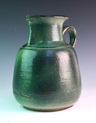 a green vase that is sitting on a table