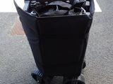a black trash can sitting on the side of the road