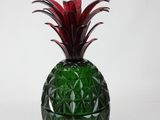 a green glass vase with a red pineapple on it
