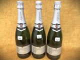 trois bouteilles de champagne posées les unes à côté des autres sur une table