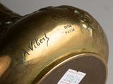 a close up of a gold vase with a label on it